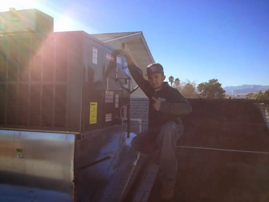 HVAC technician performing Air Duct Cleaning on a rooftop unit in Fort Smith